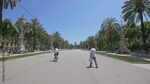 Riding bike and walking on Passeig de Lluis Companys, Barcelona