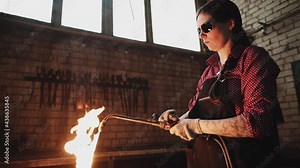 girl blacksmith works in her workshop. gas cutting of metal