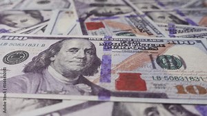 New 100 dollar banknotes rotates on a table close-up. Close-up of hundred dollar bills