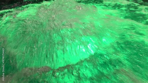 Close-up water bubbling in jacuzzi spa in swimming pool. Alluring green transparent water with air bubbles in a luxurious hot tub or jacuzzi.
