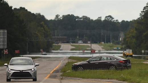 Drivers stand helpless as cars are stranded by floodwaters on U.S. 17 near Wilmington