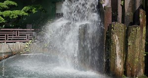 Artificial waterfall in chinese garden with rainbow