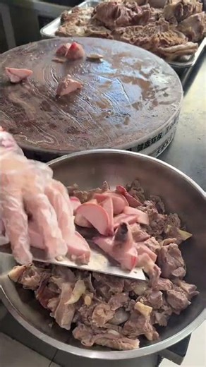 the preparation of lamb offal, specifically tripe and cooked meat on the wooden chopping block.