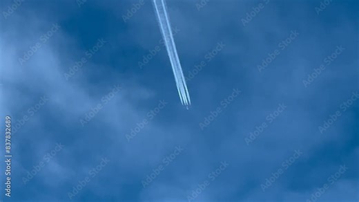 Aerial view of a huge 4-engine military jet flying very high, shot from another jet cockpit flying bellow a layer of clouds. 4K 60FPS