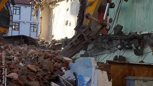 urban transformation and demolition of old buildings, a backhoe washes the old building,