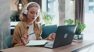Pretty student girl studying with distant teacher remote communication via laptop. Smart young woman learning new language talking with internet coach. Online education. Self-isolation.