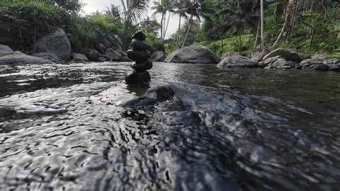 clip-4105156129-peaceful-river-stream-balanced-stones-standing-shallow
