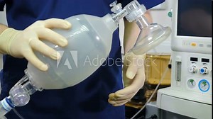 Anesthesiologist with resuscitation breathing bag or Ambu bag in hands. Life saving concept. rescue patients in emergency. Mask for artificial lungs ventilation. Breathing bag with valve inflates and