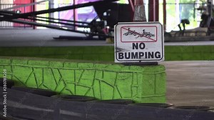 No bumping sign on go kart track with racers going by 4k