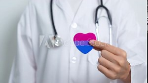 Bisexuality Celebrate Day and LGBT pride month, LGBTQ+ or LGBTQIA+ concept. Doctor holding purple, pink and blue heart shape for Lesbian, Gay, Bisexual, Transgender, Queer and Pansexual community