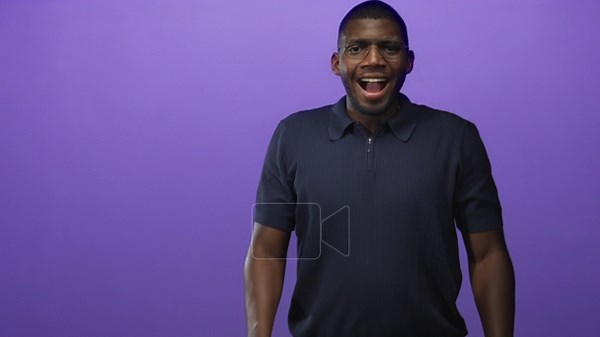 Man with glasses clapping hands and smiling while standing front facing in a studio with purple backdrop; celebration joy Stock Video Footage - Alamy
