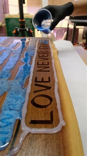 pouring blue epoxy in a CNC-carved custom Christmas gift