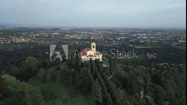 Aerial orbit around cathedral in Montevecchia, Italy named "Santuario della Beata Vergine del Carmelo". Stunning architecture and beautiful forests around. 4K drone shot.