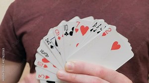 A young magician makes a fan from a deck of cards showing a magic trick.Close-up of the hand of a young male magician, he makes a fan from a deck of playing cards.