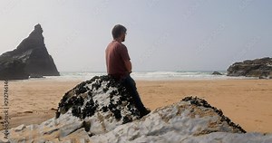 Man taking time out at the beach lost in thought and reflecting on life, different pov.