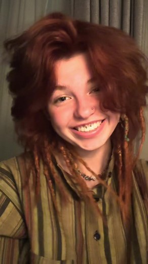 Person with Long Red Dreadlocks in Indoor Setting