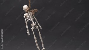 skeleton hanging on gallows over black background. Halloween video with copy space place for text. The skeleton hung on a rope. Human bones dangle from a rope Stock Video