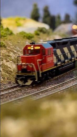 Short CN Railway with Atlas N Scale GP40 pulling a handful of cars and logs around the bend