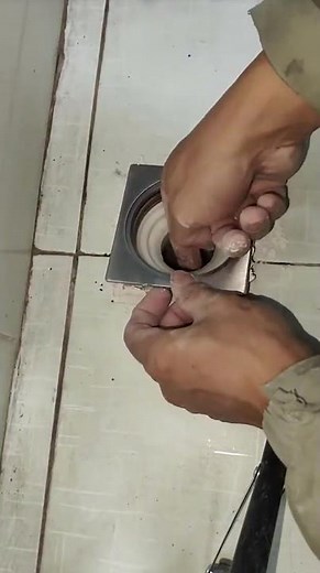 workers are installing a water drain in the floor