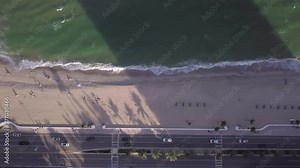 Cinematic 4k smooth sliding motion to right of ocean waves on a beach in Florida and traffic