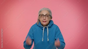 What. Why you did it. Upset frustrated annoyed elderly woman raising hands in indignant expression, quarreling, asking reason of conflict, why such stubborn. Senior old granny on pink background