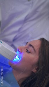 In this video, A dentist does a teeth whitening treatment on the patient with ultraviolet light