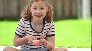 Happy little teen girl lick refreshing ice cream and joying sunny summer time at green backyard