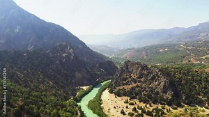 A canyon or gorge is a deep cleft between escarpments or cliffs resulting from weathering and the erosive activity of a river over geologic time scales.