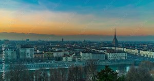 Turin time lapse video, Torino city time lapse panoramic cityscape fading from day light to night. Mole Antonelliana with Torino panorama and mountain alps in background