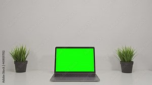 4K Green screen of laptop computer set on working space in cozy office, Zoom in shot