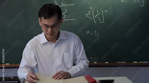 MS TU Man standing up from behind desk, looking at camera