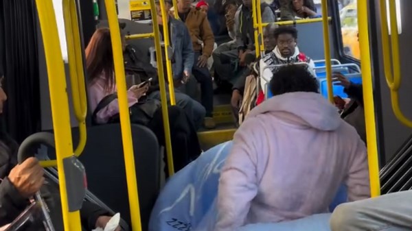 Young boy turns public bus aisle into his own cozy sleeping spot