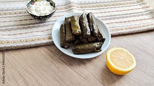Traditional oriental Turkish dolma made of grape leaves stuffed with rice on a decorative plate