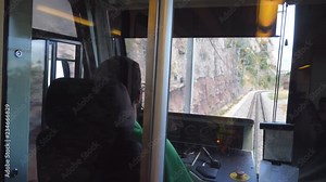 Unrecognizable train driver drives electrical train among mountain road. Point of view from driver cabin to railway tracks. Rear back view POV Slow motion Close up Stock Video