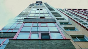 Time lapse glass on a high-rise building, two men wash the windows on a high-rise building. Bottom view