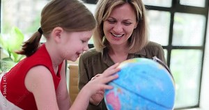 Geography teacher showing child countries on globe at lesson at school 4k movie slow motion. Preschool education concept