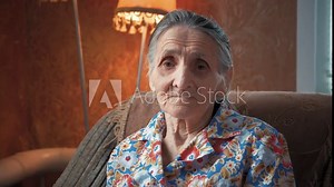 Portrait of an elderly woman 80-90 years old at home. Old odd lady with wrinkled skin face looking at camera. Detailed aged face skin. Great grandmother face expression. Senior granny female.