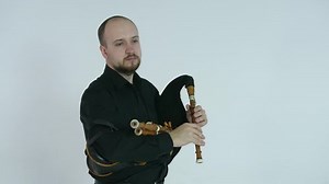 handsome young man playing the bagpipe, brass national ethnic instrument