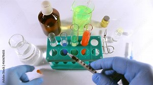 Video of a first person view laboratory inspection with coverslips, test tubes and syringe injection.