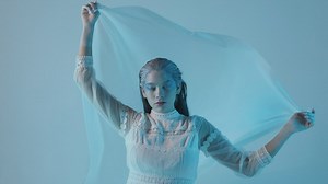 Cold and pale looking woman on a blue background - Free Stock Video