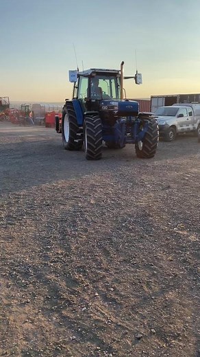 Blue Ford Tractor in Action Cutting Grass