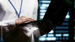 Admin using laptop to survey supercomputers providing vast computing resources and storage, enabling artificial intelligence to process massive datasets for training and inference, close up