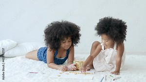 Concept of good and fun activity support children learning. Two African American girls enjoy to play with alphabet cookies by combine them as some words and they look happy together in their house.
