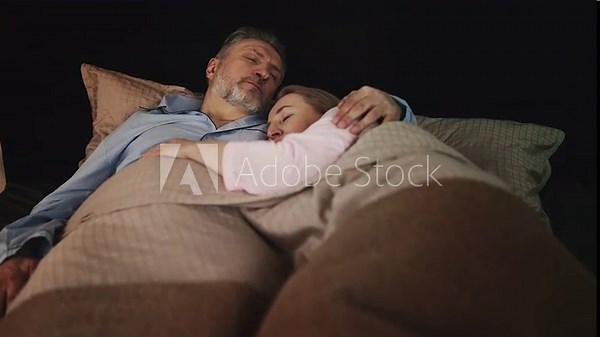 Loving middle-aged couple sleeping embraced in bed, enjoying peaceful night rest