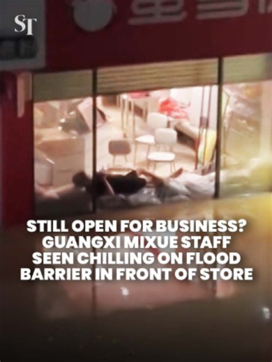 Business as usual? 🧋 A worker at a Mixue store in Guangxi was spotted relaxing on a stack of flood-control sandbags after heavy rains from Typhoon Maysak. #TyphoonMaysak #flood #Guangxi #China #Mixue