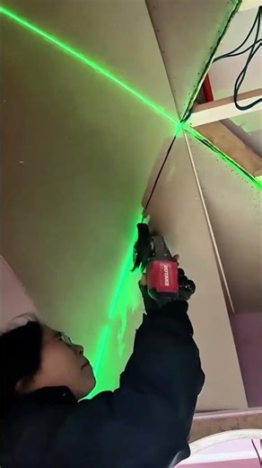 Cutting ceiling panels with an electric saw using a laser level for a straight and precise finish