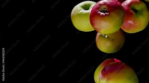 Ripe apples falling diagonally on a black background in slow motion. High quality 4k footage