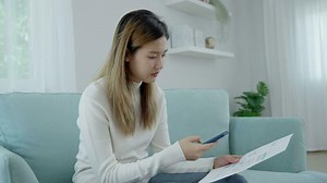 Download Modern woman use phone to scan barcode or QR codes to pay credit card bill after receive document invoice. payment, receive, paying electricity, digital payments without money, technology, scanning for free