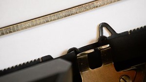 Typing the word Open with an old manual typewriter