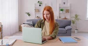 Freelancer or student works or studies online using a laptop in a home office. Remote work or online learning, highlighting the use of technology and computer in a domestic business environment.